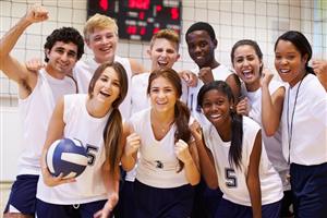 Happy co-ed volleyball team grouped with coach for a picture